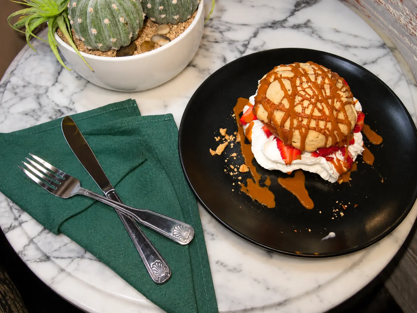 Concha filled with strawberries and cream, finished with caramel